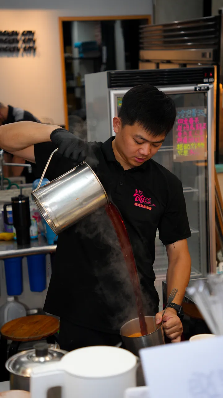 師傅提著鋼壺把熱茶拉成長長的茶柱,冒著熱氣