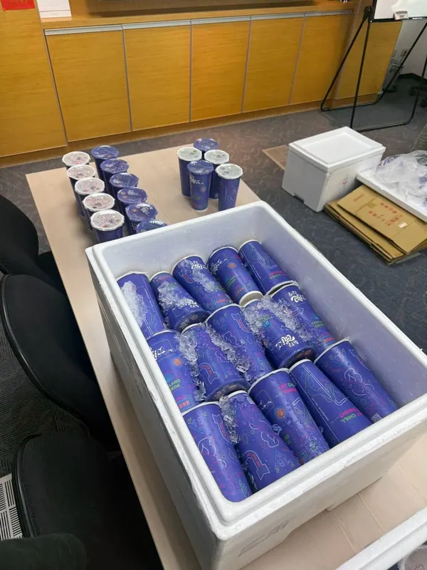 企業下午茶,會議室桌上保冷箱裡排好一杯杯封膜泰奶
