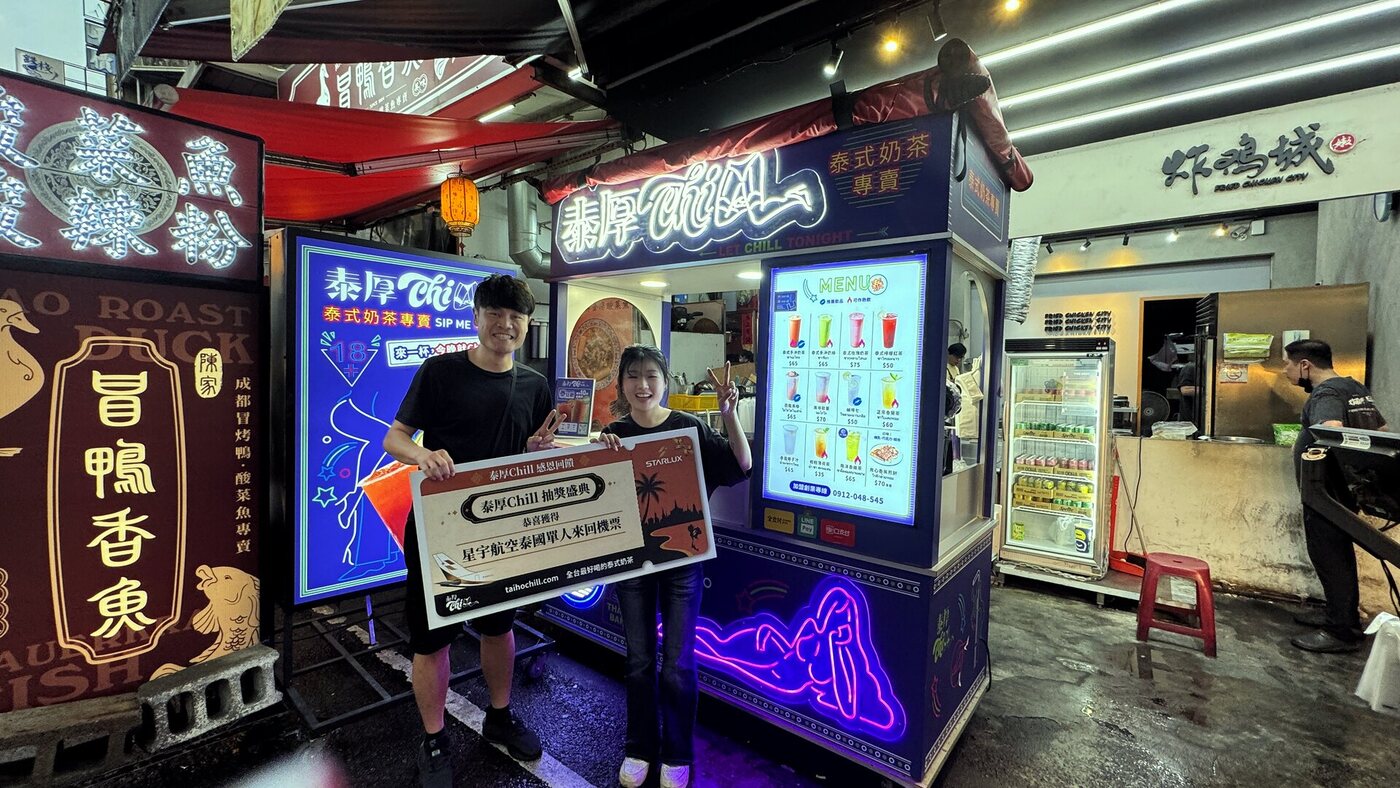 忠孝夜市旗艦店門市前，得主與店員手持星宇航空泰國機票獎牌合影