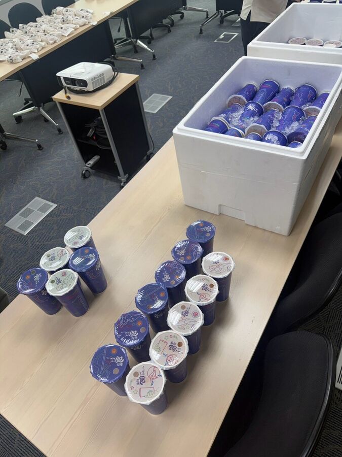 會議室桌上排開的封膜奶茶與冷藏箱