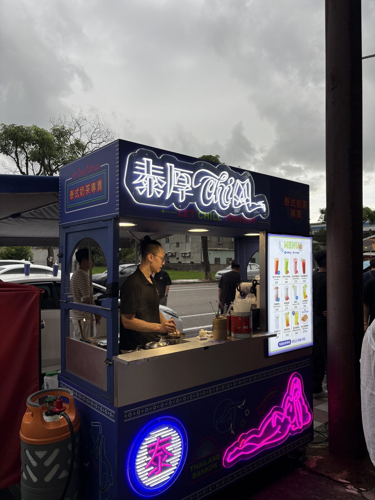 泰厚 CHILL 攤車在戶外會場，霓虹招牌亮起，夥伴在攤位裡製作飲品