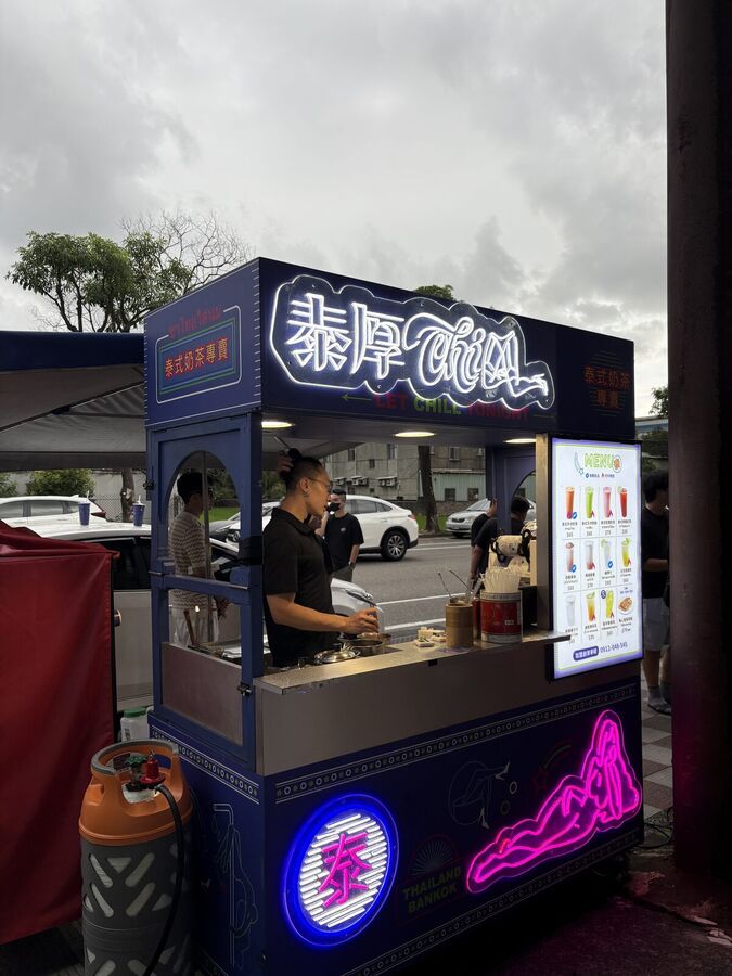 攤車正面與菜單燈箱，夥伴正在出杯